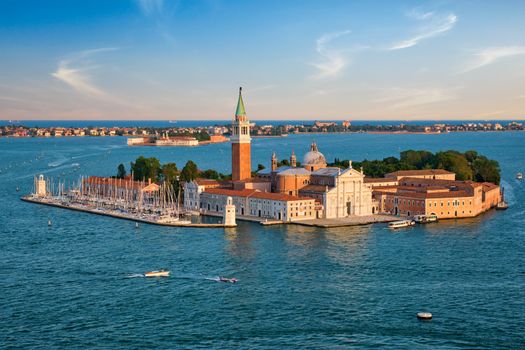 Famous Italy tourist destination - aerial view of Venice lagoon and San Giorgio di Maggiore church with boats and vaporetto traffic on sunset from St Mark's Campanile bell tower, Venice, Italy
