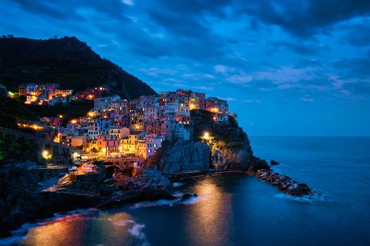 Manarola village popular european italian tourist destination in Cinque Terre National Park UNESCO World Heritage Site, Liguria, Italy illuminated in the evening