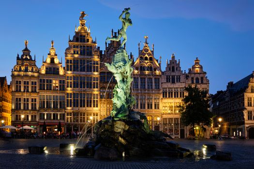 Antwerp famous Brabo statue and fountain on Grote Markt square illuminated at night and old houses. Antwerp, Belgium