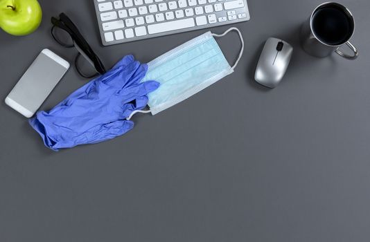 Top border of a business computer desktop prepared to work during the Coronavirus pandemic in overhead view 