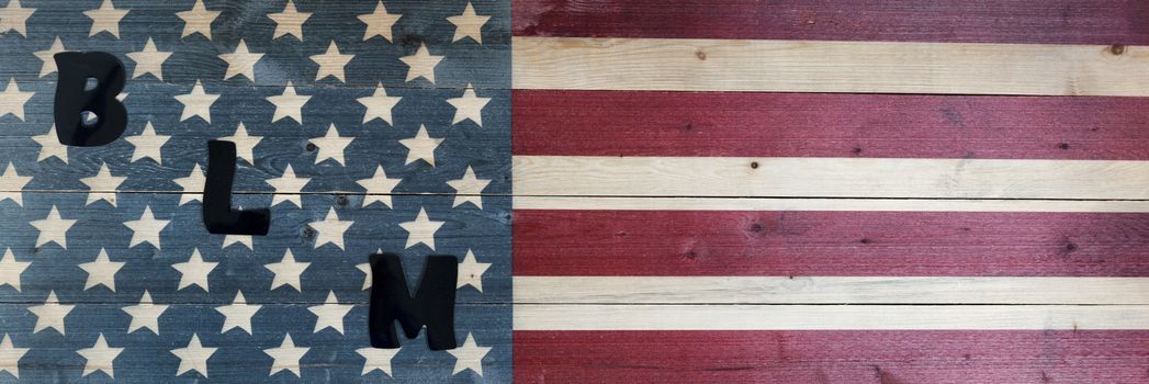 BLM capital letters on United States vintage wooden flag for black lives matter concept 