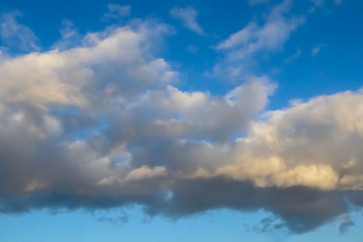 Beautiful panorama of orange and yellow clouds at sunrise and sunset in a blue sky