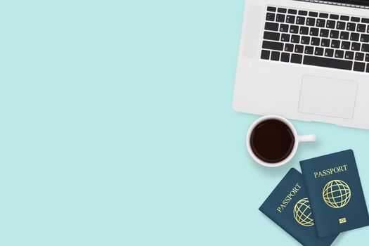 flat lay of two passport , coffee cup and computer laptop on pastel blue color background with copy space. travel , visa and vacation concept