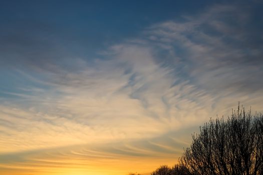 Beautiful panorama of orange and yellow clouds at sunrise and sunset in a blue sky