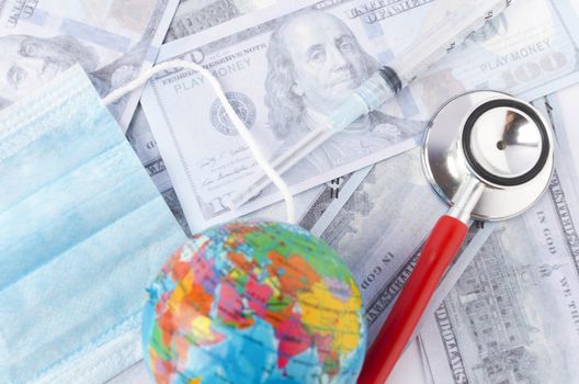 Medical face mask, stethoscope, syringe, world globe and banknotes on white background. Medical concept. Selective focus.