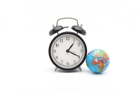 Alarm clock with world globe on white background. World time concept. Selective focus.