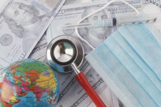 Medical face mask, stethoscope, syringe, world globe and banknotes on white background. Medical concept. Selective focus.