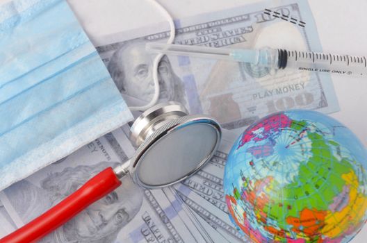 Medical face mask, stethoscope, syringe, world globe and banknotes on white background. Medical concept. Selective focus.