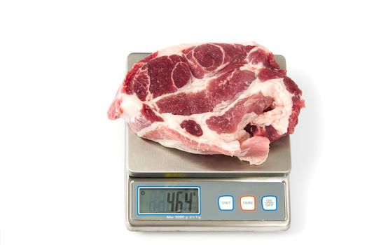 Raw pork meat steak on the digital scale, on white background