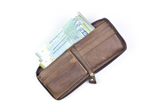 Malaysia bank note with leather purse on white background.