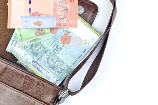 Malaysia bank note with sling bag on white background.