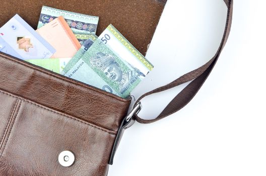 Malaysia bank note with sling bag on white background.