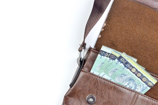 Malaysia bank note with sling bag on white background.