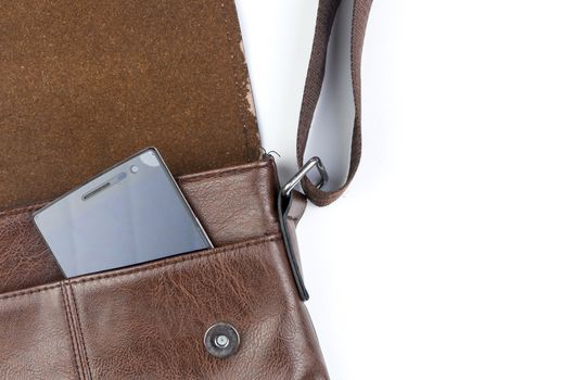 Leather sling bag with smartphone on white background.
