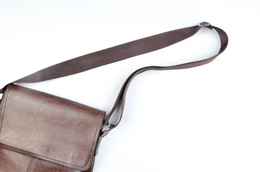 Brown sling bag on white background. Selective focus.