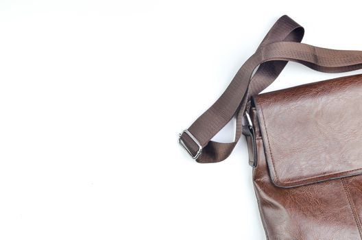 Brown sling bag on white background. Selective focus.