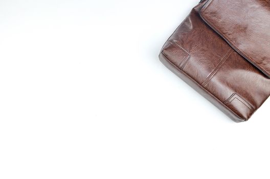 Brown sling bag on white background. Selective focus.