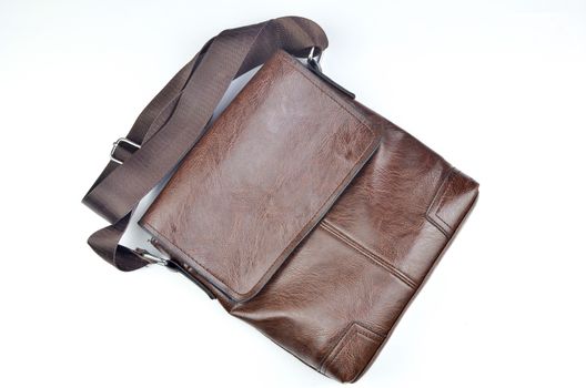 Brown sling bag on white background. Selective focus.