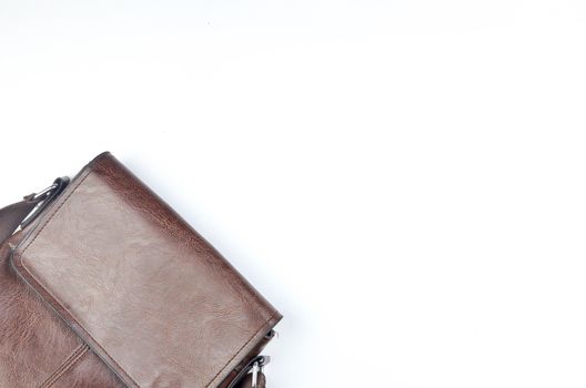 Brown sling bag on white background. Selective focus.