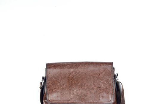 Brown sling bag on white background. Selective focus.