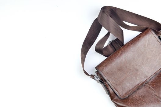 Brown sling bag on white background. Selective focus.