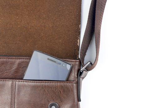 Leather sling bag with smartphone on white background.