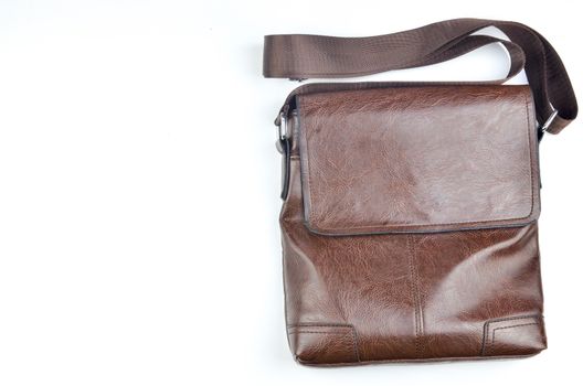 Brown sling bag on white background. Selective focus.