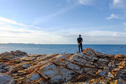 A man standing watching the sea on a rock At Khao Laem Ya.