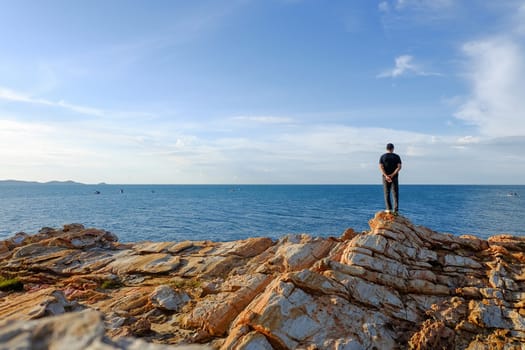 One man stood holding his hand behind him and standing at the viewpoint at Khao Laem Ya, Rayong, Thailand.