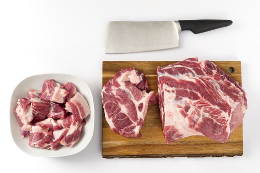 Raw pork chops in white palte, andraw pork meat on wooden cutting board. copy space