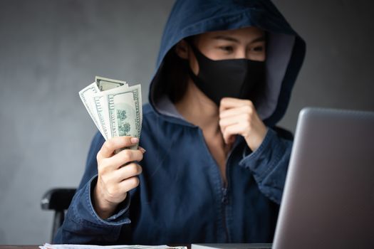 Professional hacker women Wearing a blue shirt with a hood Stealing data from online computer systems By releasing viruses into the system By using laptops and keyboards concept of malware and hacker