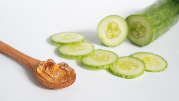 organic natural skincare concept. clear transparent gel in wooden spoon with cucumber slice isolated on white background