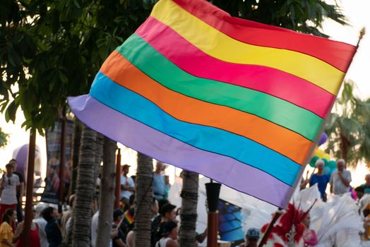 waving rainbow of gay flag and crowd of people in Pride Rainbow Festival Parade. LGBT rights concept