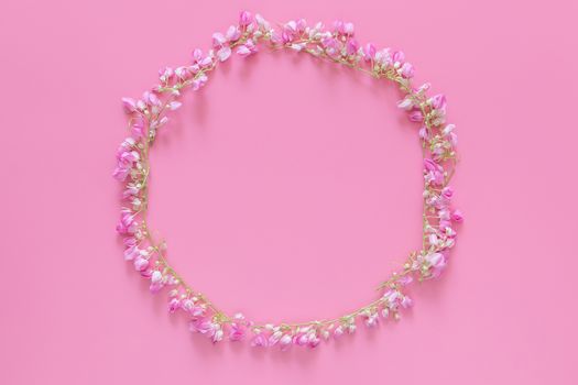 flat lay of Flower crown ,floral wreath circle made from pink flowers isolated on pink background, top view. flower creative composition with copy space