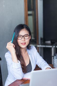 Business women wear glasses Beautiful asians Have fun in the office inside the house during work at home.