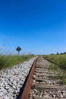 An old stripe with a sign on the side that says 100, with a blue sky in the background. Railway in Beja, Portugal.