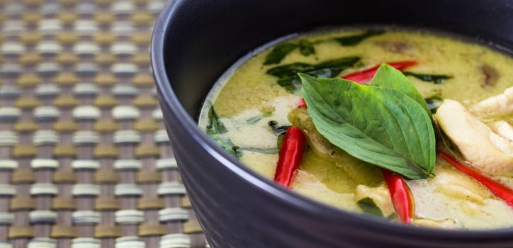 Thai green curry with chicken meat and sweet basil on top