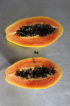 Papaya fruit halved in two halves. Two halves of papaya fruit.