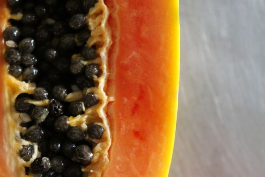 Close up of papaya fruit on the kitchen table. Macro papaya fruit, papaya seeds.