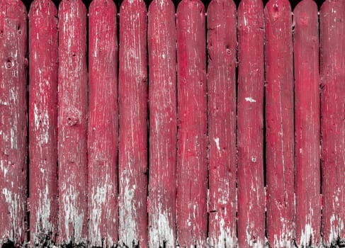 Rustic old fence with peeling red paint makes a versatile background.