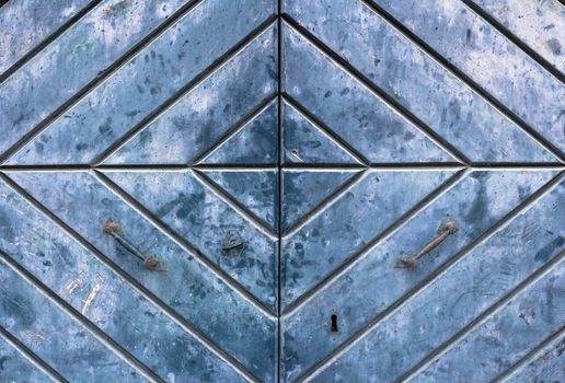 Doorknob and metal door handle on ancient blue door