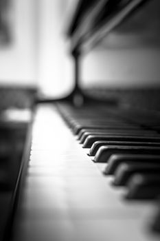 Extreme close-up of piano keys with blurred background. One key in focus.