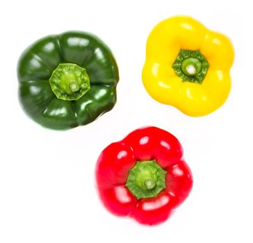 Three peppers in red yellow and green. Together they form a circle, in a white background. Seen from above.