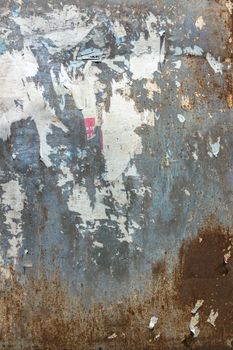 Texture of torn advertisement on an old rusty billboard panel. Ideal for your creative backgrounds.