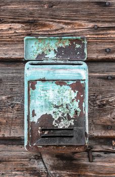 Rusty metal mailbox on the wooden doorway