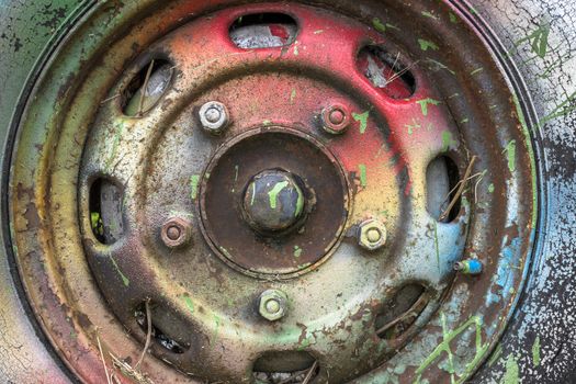 An old abandoned pickup truck, painted with bright colors.