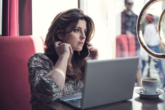 Beautiful young business woman working while drinking coffee in the restaurant.