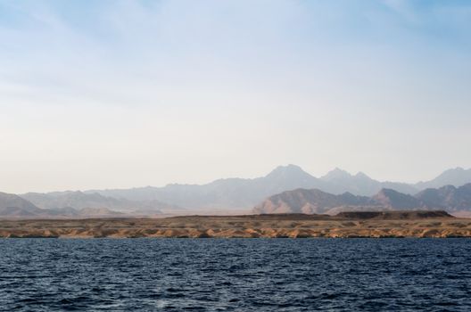 landscape rocky coast of the Red Sea and
blue sky with clouds in Sharm El Sheikh Egypt