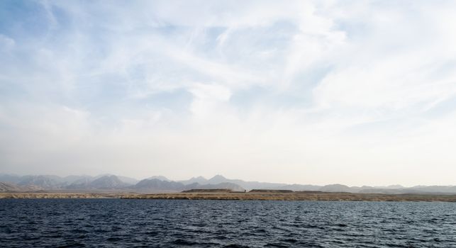 landscape rocky coast of the Red Sea and
blue sky with clouds in Sharm El Sheikh Egypt