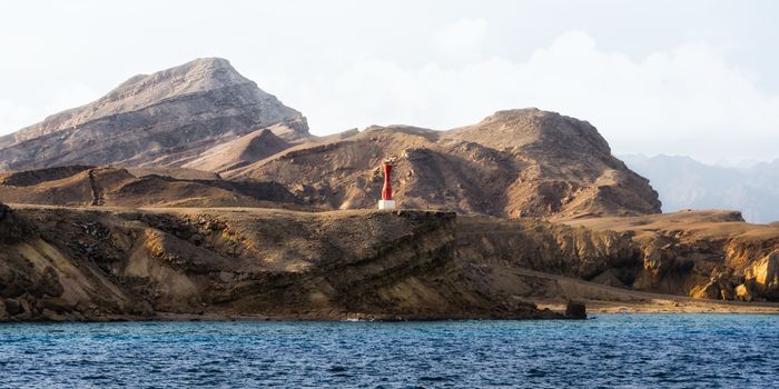 lighthouse on the rocky shore of the Red Sea without people in Egypt landscape